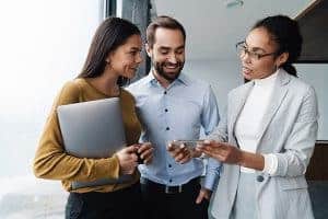 Cheerful business professional standing and having a casual talk in the office